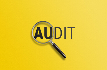 A magnifying glass focuses on AUDIT against a yellow background 