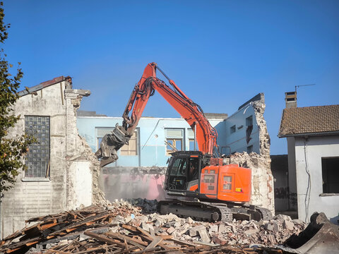 Escavadora de bra&ccedil;o longo no desmantela  de um edif&iacute;cio existente para preparar o terreno para novo empreendimento residencial