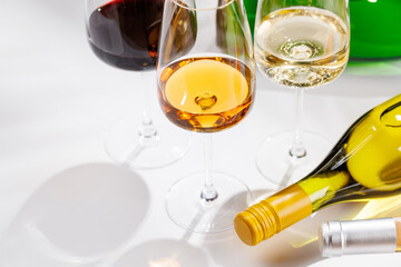 Different wine bottles and glasses on white background