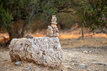 A stack of stones on a larger rock in a natural outdoor setting