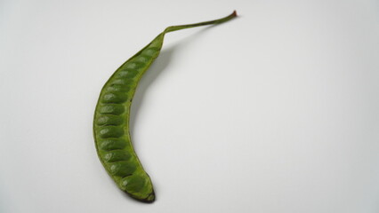 Isolated white one green petai or pete or mlanding (Parkia speciosa) board consisting of several petai pieces.