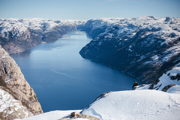 Skier Descending Snowy Mountain Overlooking Fjord