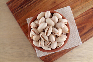 Close up of pistachios in wooden bowl