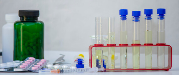 Microscope, medicine bottles, and magnifying glass on a white table for medical research