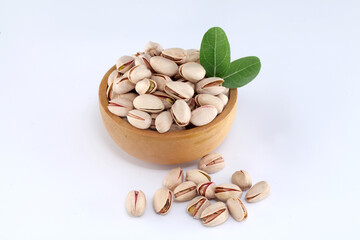 Pistachios spilled out of wooden bowl,close up