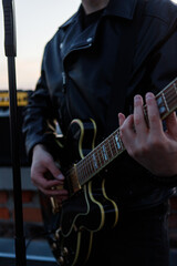 Musician playing electric guitar close-up in dark setting