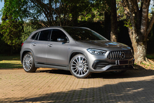 Gray Mercedes-AMG GLA 35 front view three quarters, Performance SUV parked under trees