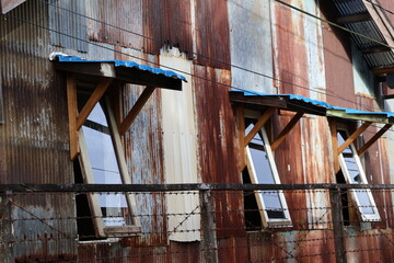 building with rusty galvanized metal sheets wall texture. old tin background. rusty zinc texture background