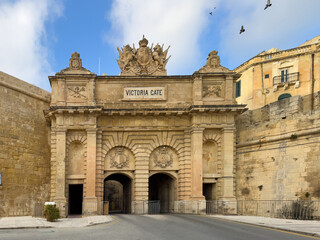 The monumental Victoria Gate in Valletta, Malta, a historical stone archway and fortification built during the British period, featuring intricate heraldic crests