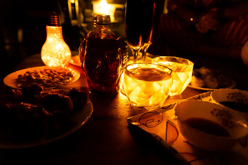 cozy night atmosphere with glowing decor and drinks on wooden table