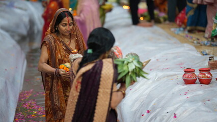 Women devotees stand in the river during Chhath Puja in Bihar, offering fruits and soup to the rising Sun God.