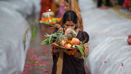 During Chhath Puja in Bihar, women dressed in colorful sarees stand waist-deep in the river, offering fruits, flowers, and homemade soup to the Sun God