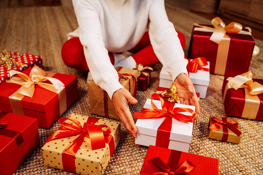 Preparation for Christmas. Woman packing or unwrapping Christmas presents.  - Powered by Adobe