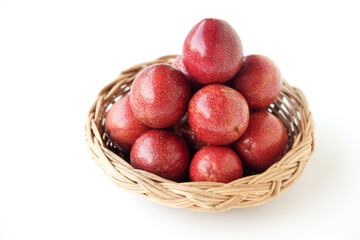 Fresh ripe purple passion fruits neatly stacked in a woven basket on white background. Tropical organic fruit rich in vitamins and antioxidants, perfect for healthy lifestyle, diet, and natural food 