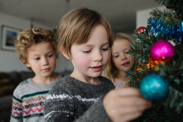 Children decorating Christmas tree.