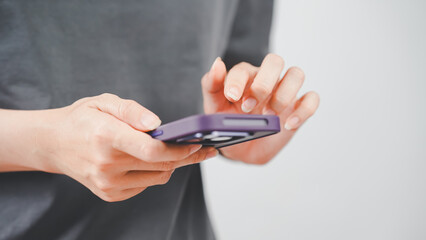 Close-up of a person using a smartphone with a purple case, touching the screen in a modern lifestyle or communication context.