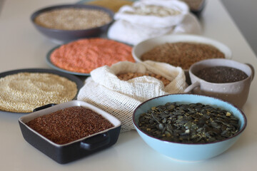 Bowls and bags full of various healthy grains and legumes. Selective focus.