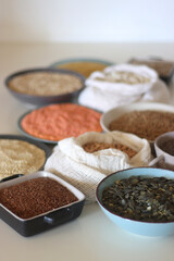 Bowls and bags full of various healthy grains and legumes. Selective focus.