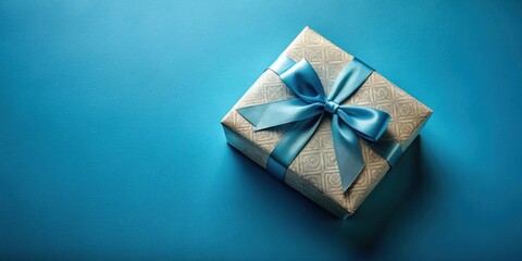 A luxuriously wrapped present, tied with a vibrant blue ribbon, sits elegantly on a smooth azure surface, ready for a special occasion.