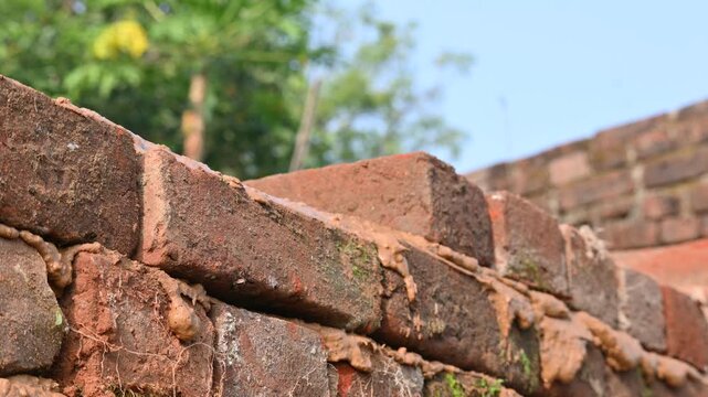 A Mason bricklayer installing bricks on construction site. shovel in construction labour hand. Bricklayer laying bricks on mortar on new residential house construction. Hand of construction worker.
