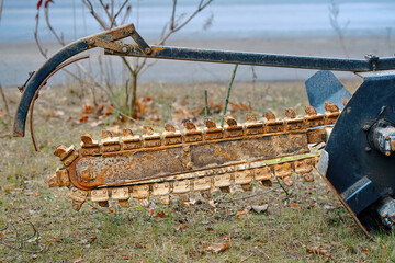 Walk-behind trencher attachment blade, trencher part closeup. Shark tooth on the chain or chain trencher. Rusty shark tooth blade