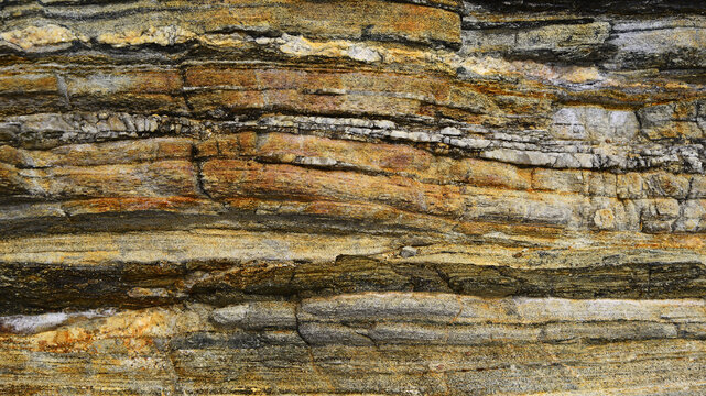 Sedimentary rock in strata of different composition. Geological studies. Wallpaper or natural background. 