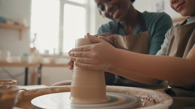 A child learning pottery from a teacher, exploring creativity and craftsmanship in a hands-on workshop. 