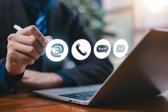 Businessman using digital communication icons such as email phone chat and message on a laptop representing online contact, customer service and technology connection in modern business communication.