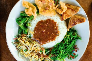 Delicious indonesian nasi campur with fried tempeh and vegetables