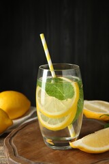 Refreshing water with lemons and mint on table, closeup