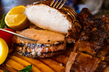 Thick slices of boneless grilled beef picanha, hand-cut on a wooden chopping board.Ideal for cooking magazines