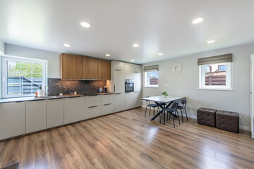 Modern Home Bright Kitchen and Dining Space with Stylish Wooden and White Cupboards