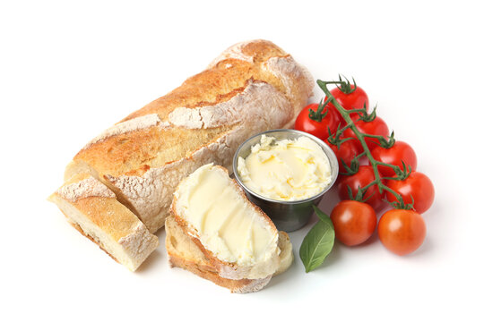 Cut baguette with butter, basil and tomatoes isolated on white - Powered by Adobe