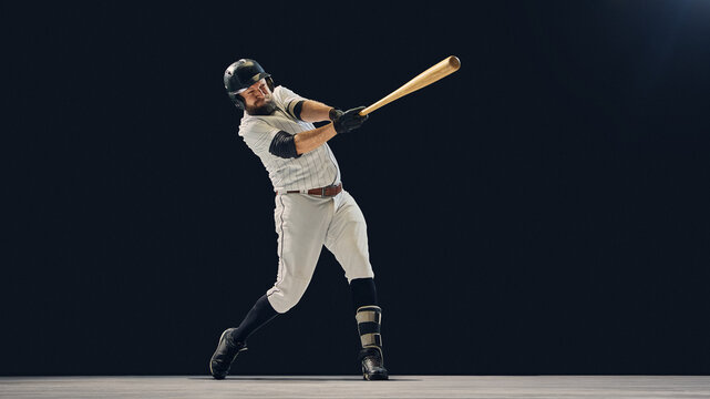 Baseball player mid-swing showing impact position and kinetic chain movement. Concept of biomechanical study, fitness campaign visuals, and professional hitting technique education.