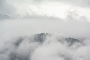 Alpine granite mountain peak covered in mist and clouds. La Vanoise national park, Savoie, France 