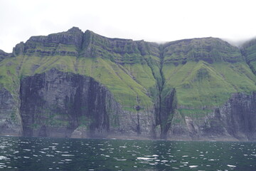 Sailing below the steep and dramatic Vestmanna cliffs in the Atlantic Ocean off the coast of Faroe Islands © ChrisOvergaard