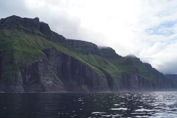 Sailing below the steep and dramatic Vestmanna cliffs in the Atlantic Ocean off the coast of Faroe Islands © ChrisOvergaard