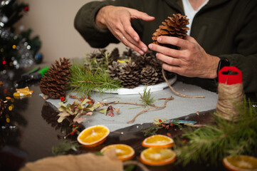 Crafting Christmas Decorations With Pinecones, Twine, And Dried Oranges At Home