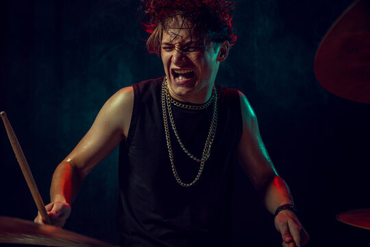 Drummer smiling with joy while performing live on stage with passion. Concept of happiness, motivation, emotional health, music posters, and artistic confidence.