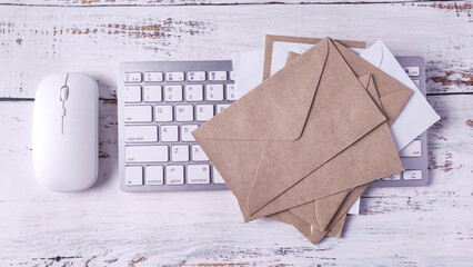 Digital and Physical Mail: Computer Keyboard, Mouse, and Stacked Paper Envelopes