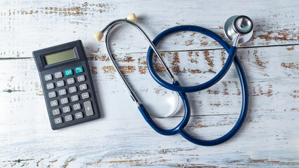 Stethoscope and Calculator on a Wooden Background: Analyzing Healthcare Costs, Medical Billing, and Financial Planning