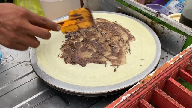 Process of making Kue Leker or Indonesian crepes with chocolate and cheese toppings