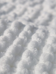 extreme close up of a soft white plush knitted blanket texture with selective focus