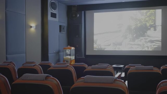 Interior view of an empty modern movie theater with comfortable seating and a popcorn machine