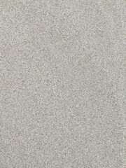 Close-up top-down view of fine, dry sand. Abstract background of a beige beach or desert sand texture.