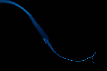 Minimalist abstract background with a single glowing blue neon line on a pure black backdrop. Simple futuristic design element. Blue laser abstract matrix background 