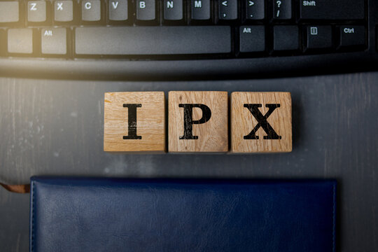 Wooden blocks displaying the letters &ldquo;IPX&rdquo; placed on a computer keyboard, representing technology, digital communication, information concepts, and modern workspace elements.