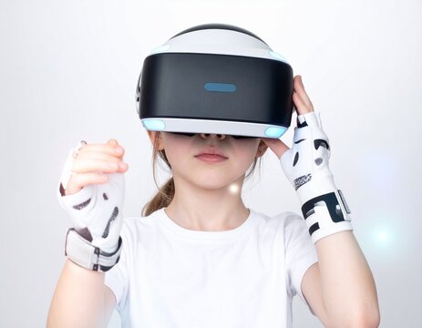 Kind tr&auml;gt futuristisches VR-Headset und Handschuhe