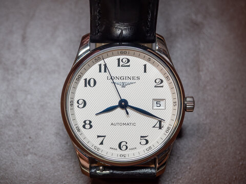 BANGKOK, THAILAND - AUGUST 13 : Longines Master Collection, blue steel hands, white dial with numeric markers, alligator strap, put on table in Bangkok, Thailand, on August 13, 2025.