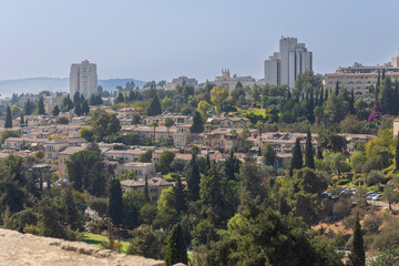 jerusalem, Israel, 2 November 2025, A panoramic view of a neighborhood, showing densely packed traditional stone houses with tiled roofs interspersed with cypress trees